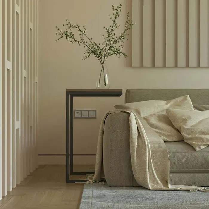 Linen sofa beside a slim side table and a vase of branches